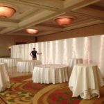 Event space setup with white draping and tables, ideal for religious ceremonies and weddings, highlighting Party Time Rental and Events' decor services.