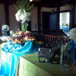 Centerpiece sets the table Food service setup featuring a variety of colorful platters, a beverage dispenser, and floral arrangements, emphasizing warm and cold drink options for events like weddings and parties.