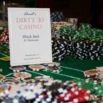 Casino table setup featuring poker chips and a sign for "Dirty 30 Casino" with blackjack information, highlighting Party Time's event printing services for themed parties.