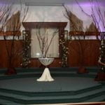 Wedding altar setup featuring natural elements, decorative branches, and elegant linens, suitable for wedding ceremonies and events.