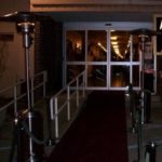 Outdoor heaters positioned at an entrance, providing warmth for guests at events and parties, enhancing comfort in cooler weather.