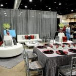 Elegant event setup featuring silver Chiavari chairs around a table with red accents, showcasing rental options for weddings and special occasions.