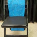Dressed black garden chair with a blue seat cover, suitable for event rentals in Little Rock, Arkansas.