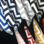 Chevron print linens in various colors including blue, black, gray, red, yellow, and white, showcasing a vibrant selection for event table settings.