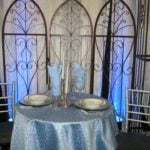 Silver Chiavari chairs set at an elegantly decorated table with blue tablecloth and decorative elements, showcasing event rental options for weddings and special occasions.