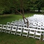 White garden chairs arranged in rows on grass, ideal for weddings and events, showcasing rental options from Party Time Rental and Events.